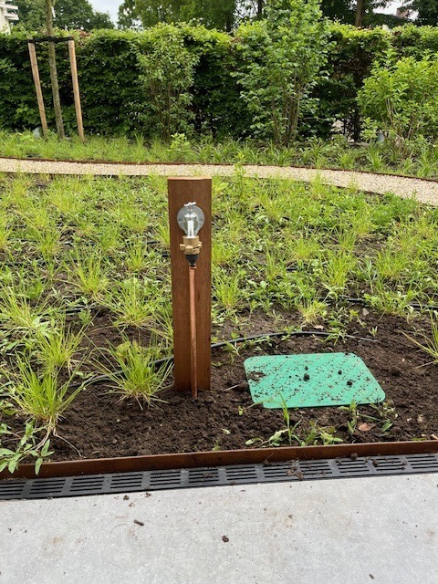 Sproeier op paaltje in aanleg tuinborder